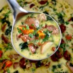 Kielbasa Potato Soup in ladle held up over pot