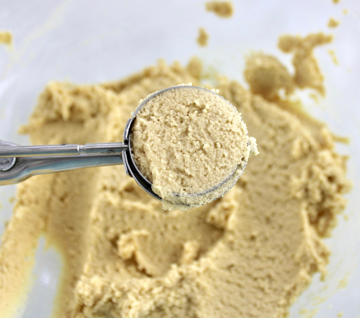 Pecan Pie Cookie dough in cookie scoop held over glass bowl