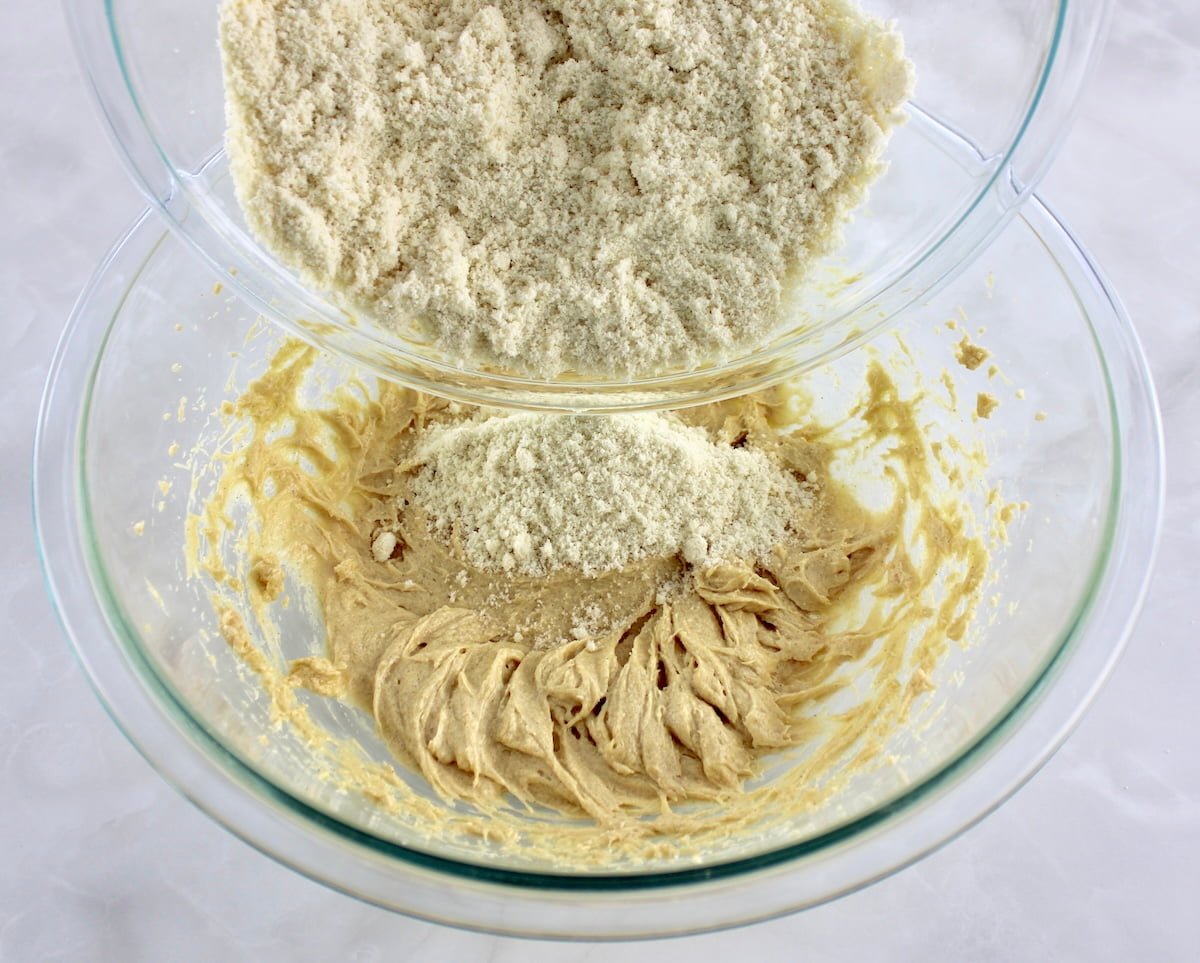 dry ingredients for Pecan Pie Cookies being poured into the wet ingredients in glass bowls