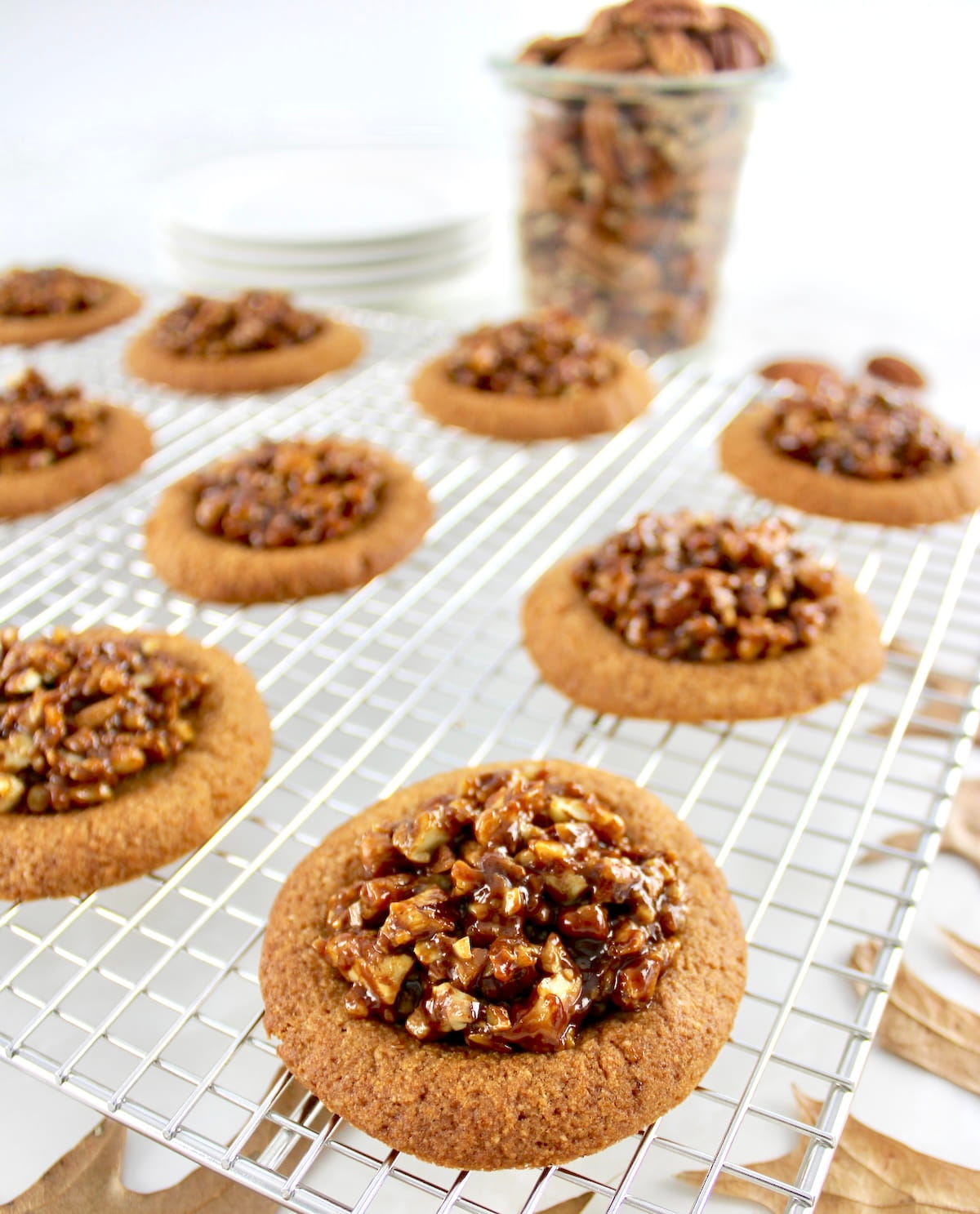 Pecan Pie Cookies on cooling rack with pecans in glass jar in back