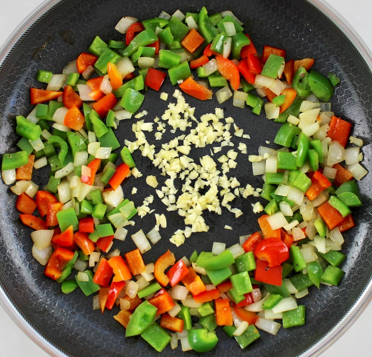 skillet with diced peppers, onions and garlic