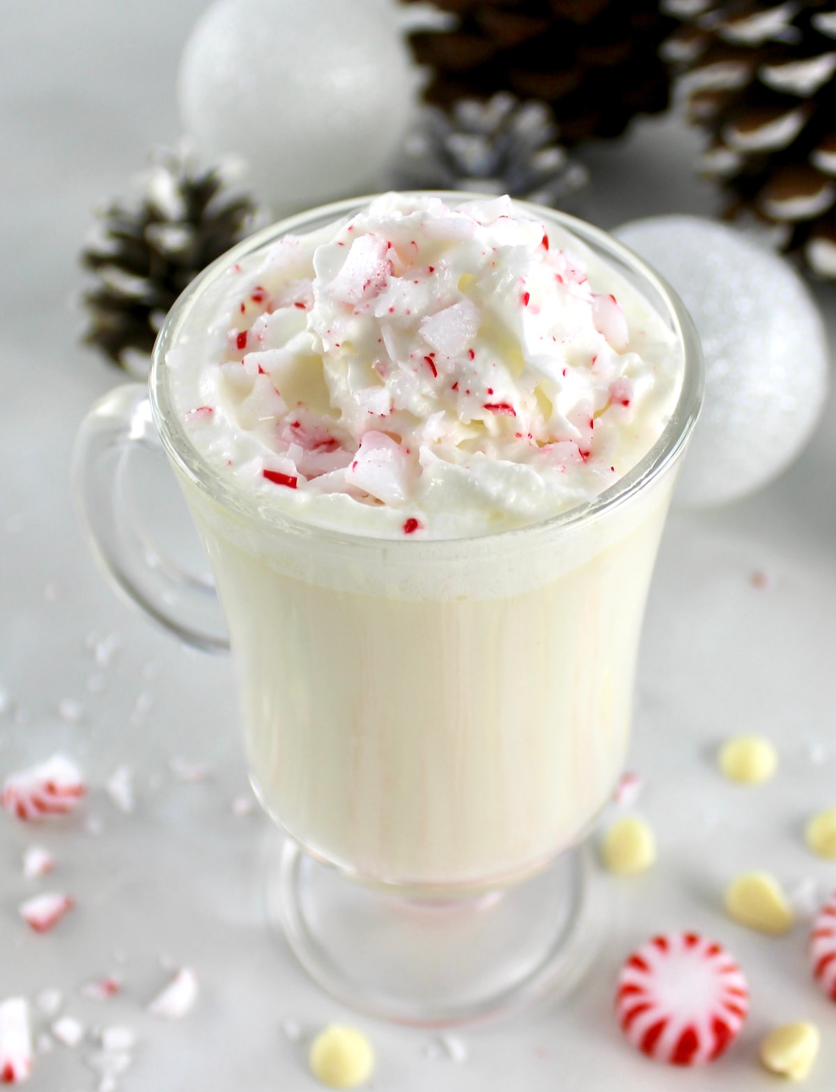 Peppermint White Hot Chocolate in glass with whip cream and crush peppermints on top