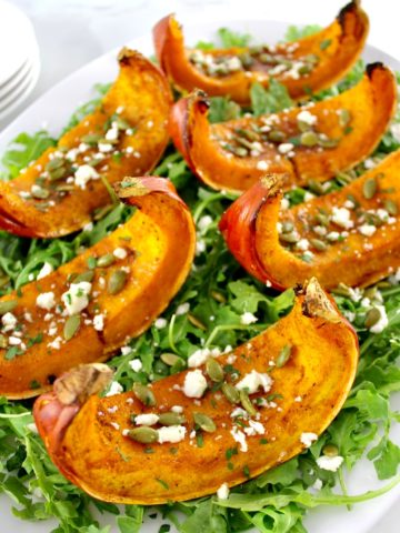 Roasted Pumpkin wedges on bed of arugula with pumpkin seeds and feta on top