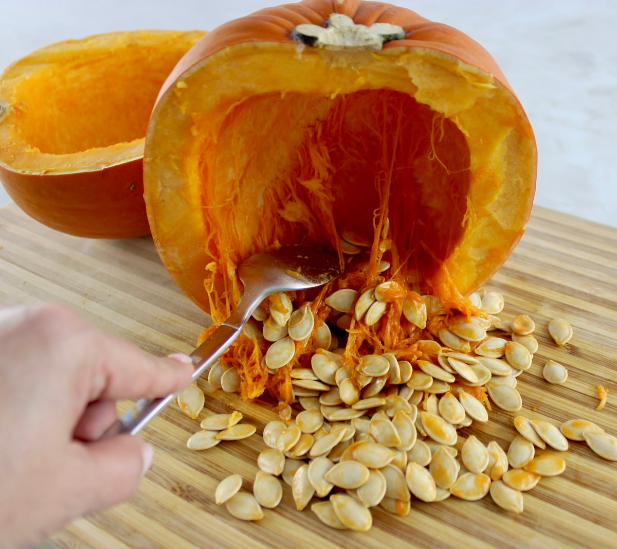 cleaning out pumpkin half scooping out seeds