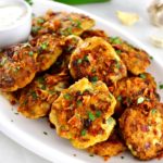Jalapeño Popper Chicken Fritters on white plate with ranch dressing on the side