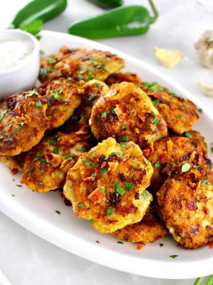 Jalapeño Popper Chicken Fritters on white plate with ranch dressing on the side