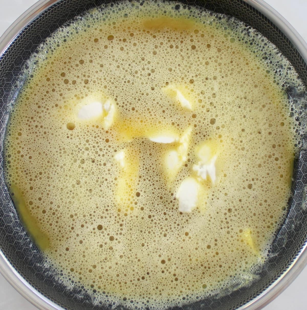 beaten raw eggs with clumps of ricotta cheese in whillet