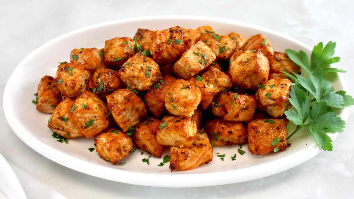 Cajun Salmon Bites on white oval platter with parsley garnish