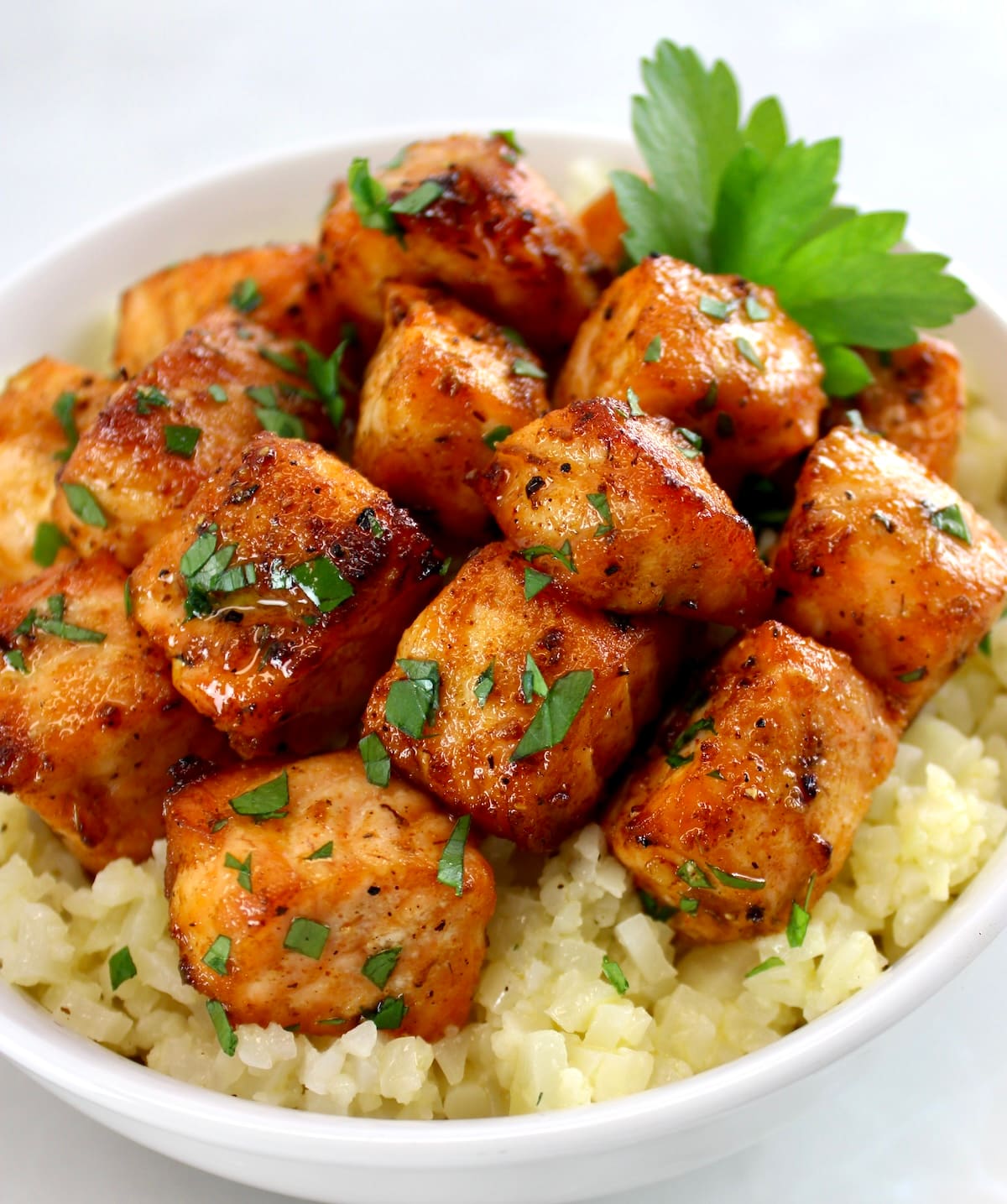 Cajun Salmon Bites in white bowl with cauliflower rice