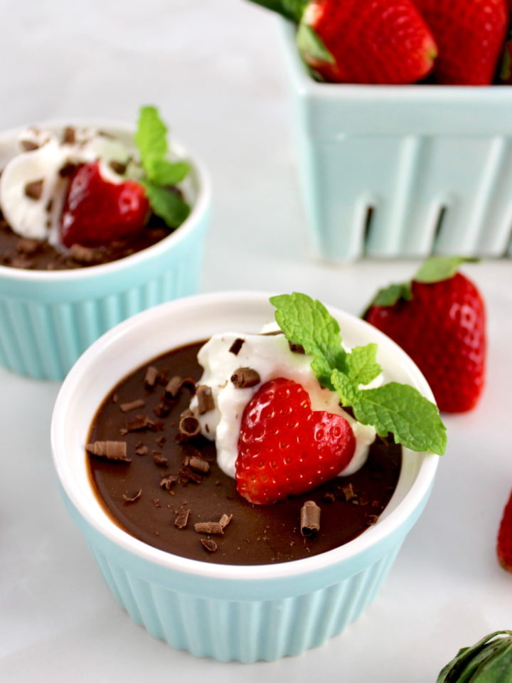 Chocolate Pots de Crème in ramekin with whip cream and a strawberry on top