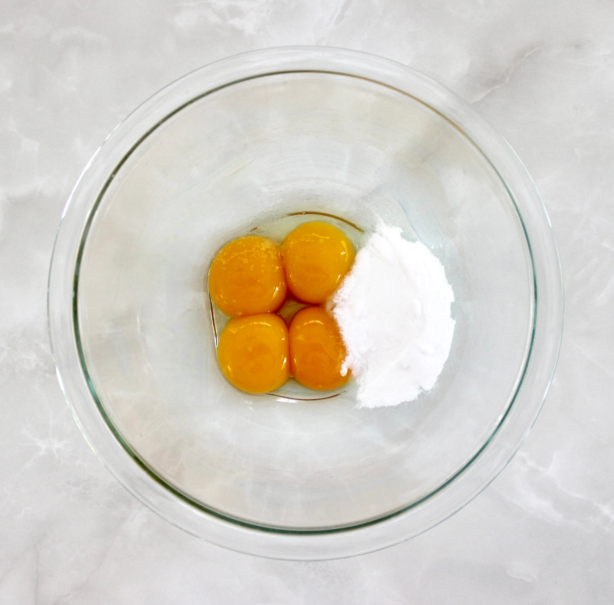 4 egg yolks and sweetener in glass bowl