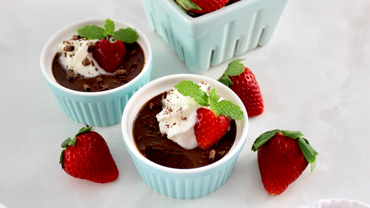 overhead view of Chocolate Pots de Crème in blue ramekin with whip cream and strawberry on top