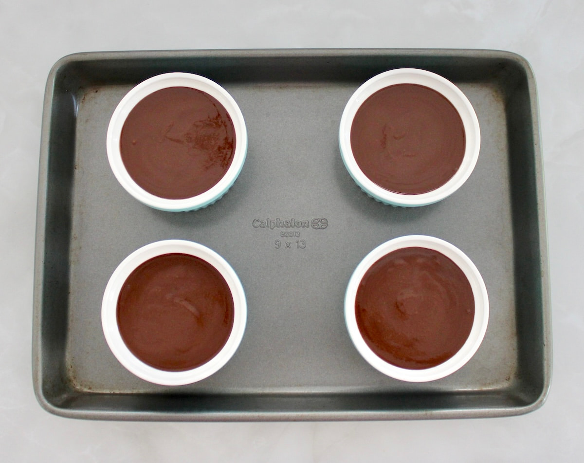 4 blue ramekins with Chocolate Pots de Crème on baking sheet