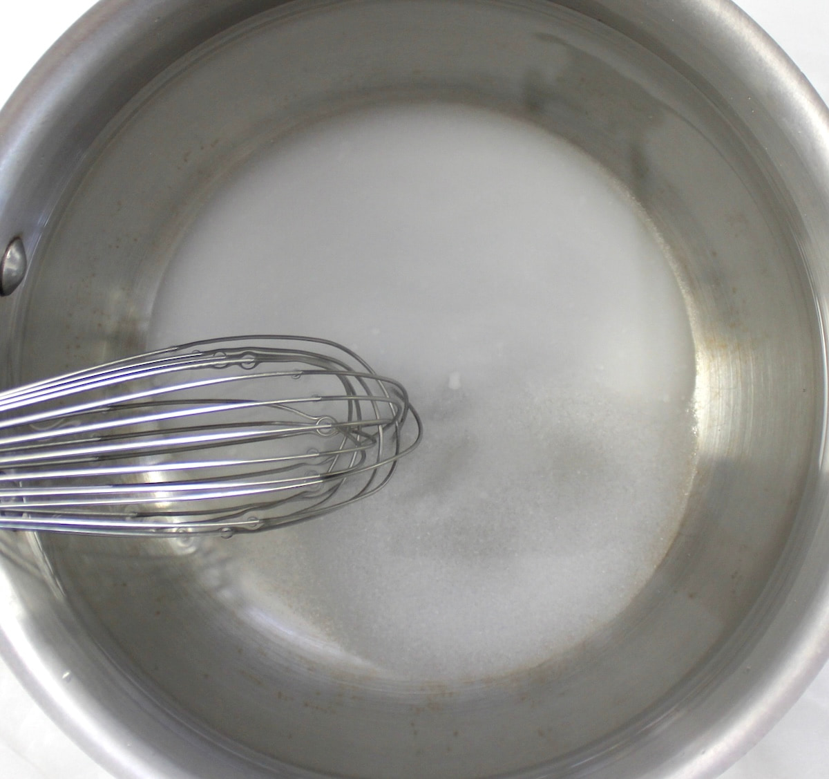 water, vinegar and sweetener in saucepan with whisk