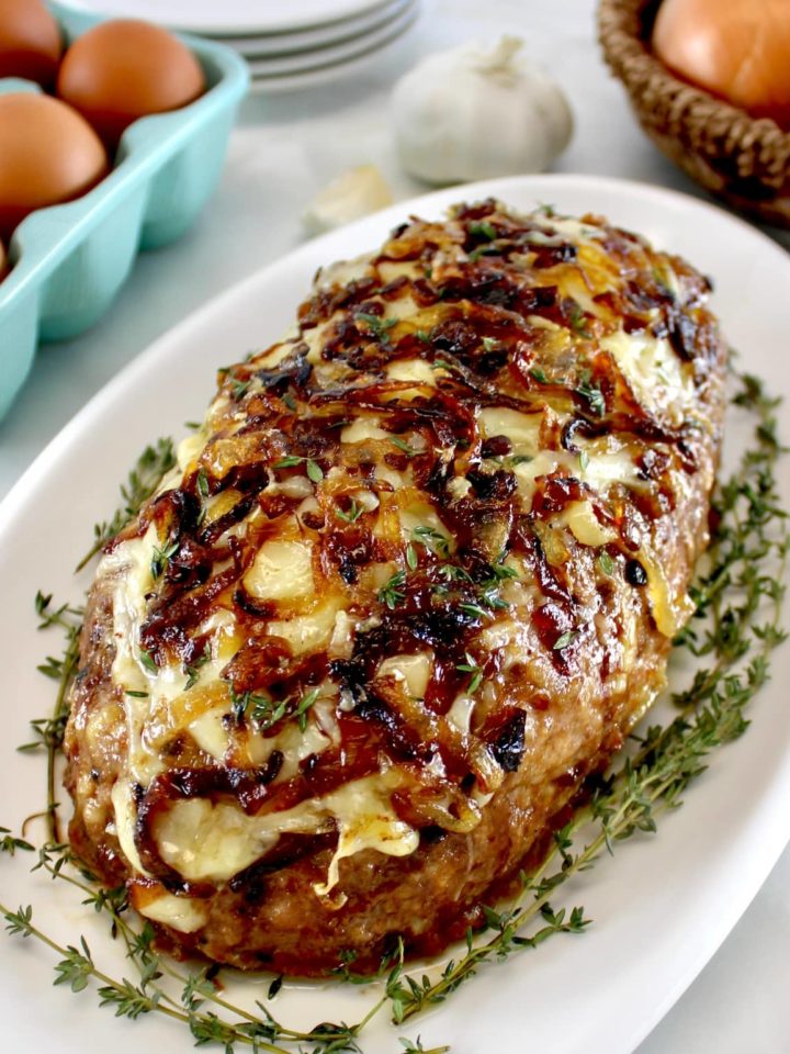 French Onion Meatloaf on white platter with fresh time around