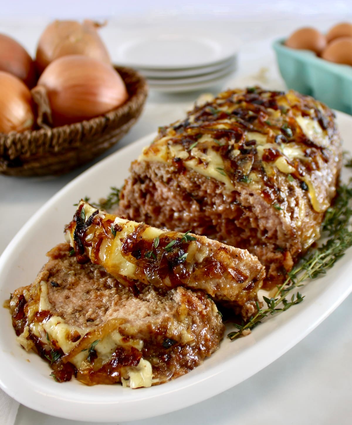 French Onion Meatloaf on white platter with 2 slices