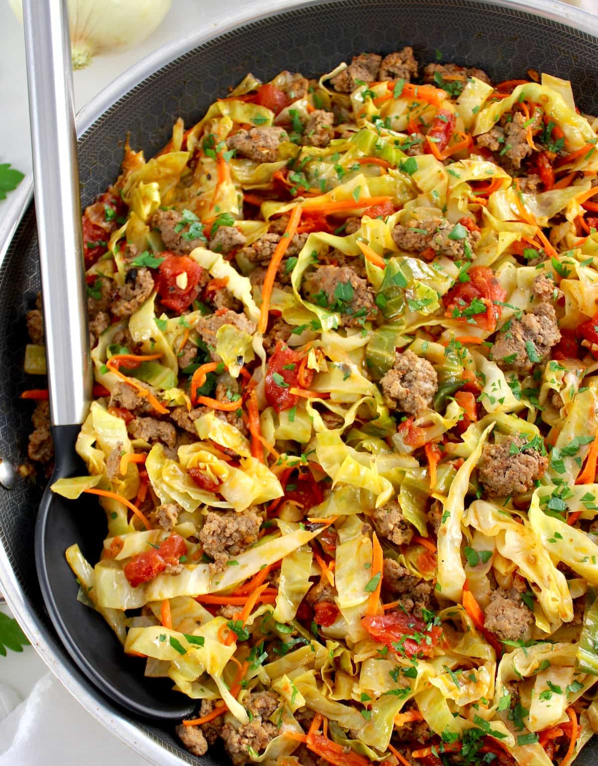 closeup of Ground Beef and Cabbage Skillet in skillet with serving spoon
