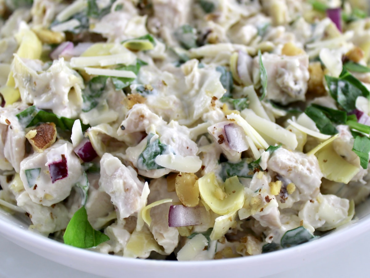 closeup of Spinach Artichoke Chicken Salad in white bowl