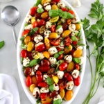overhead view of Chopped Caprese Salad on white oval platter