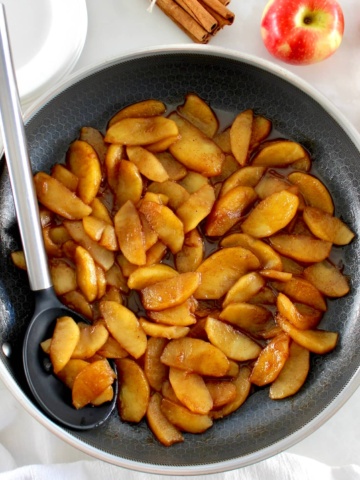 Easy Cinnamon Apples in skillet with serving spoon on side