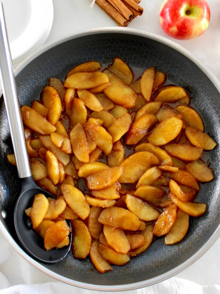 Easy Cinnamon Apples in skillet with serving spoon on side