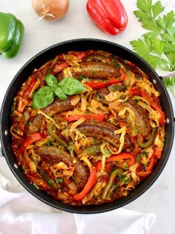 overhead view of Italian Sausage and Peppers Cabbage Skillet with fresh basil garnish