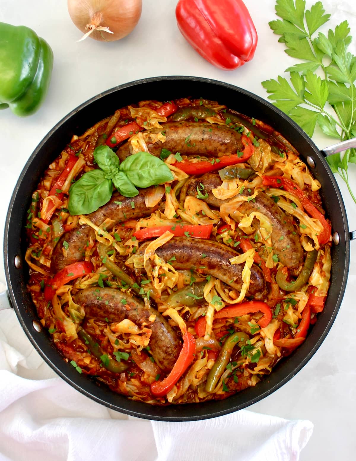 overhead view of Italian Sausage and Peppers Cabbage Skillet with fresh basil garnish