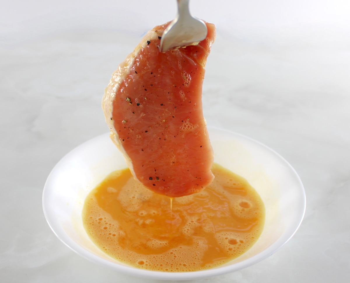 pork chop dipped in egg dripping off