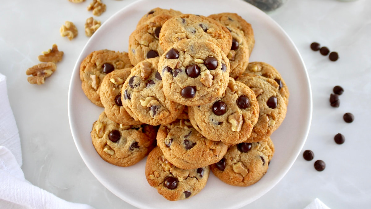 overhead view of Chocolate Chip Walnut Cookies stacked up on white plate
