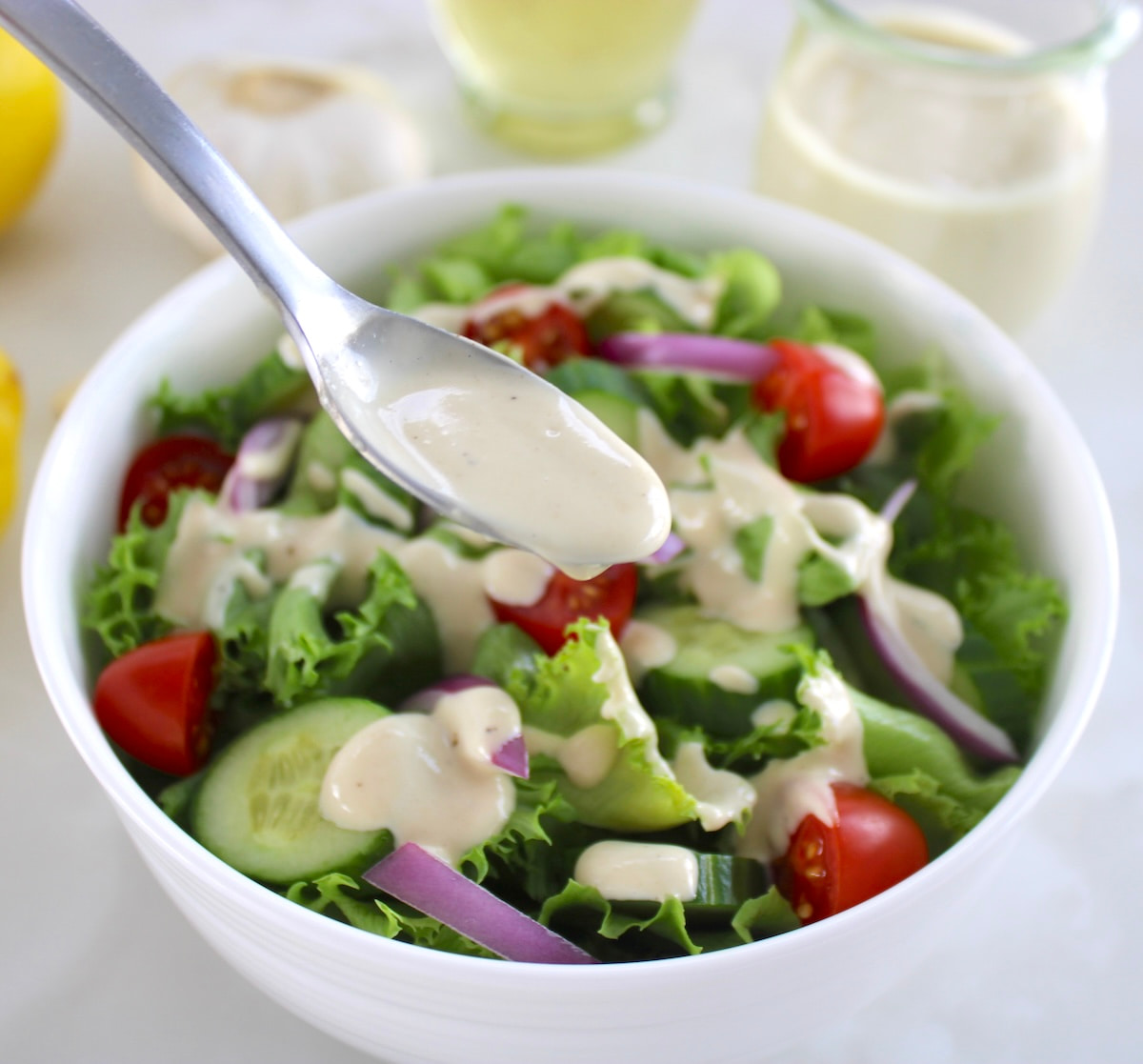 Lemon Tahini Dressing in spoon over salad