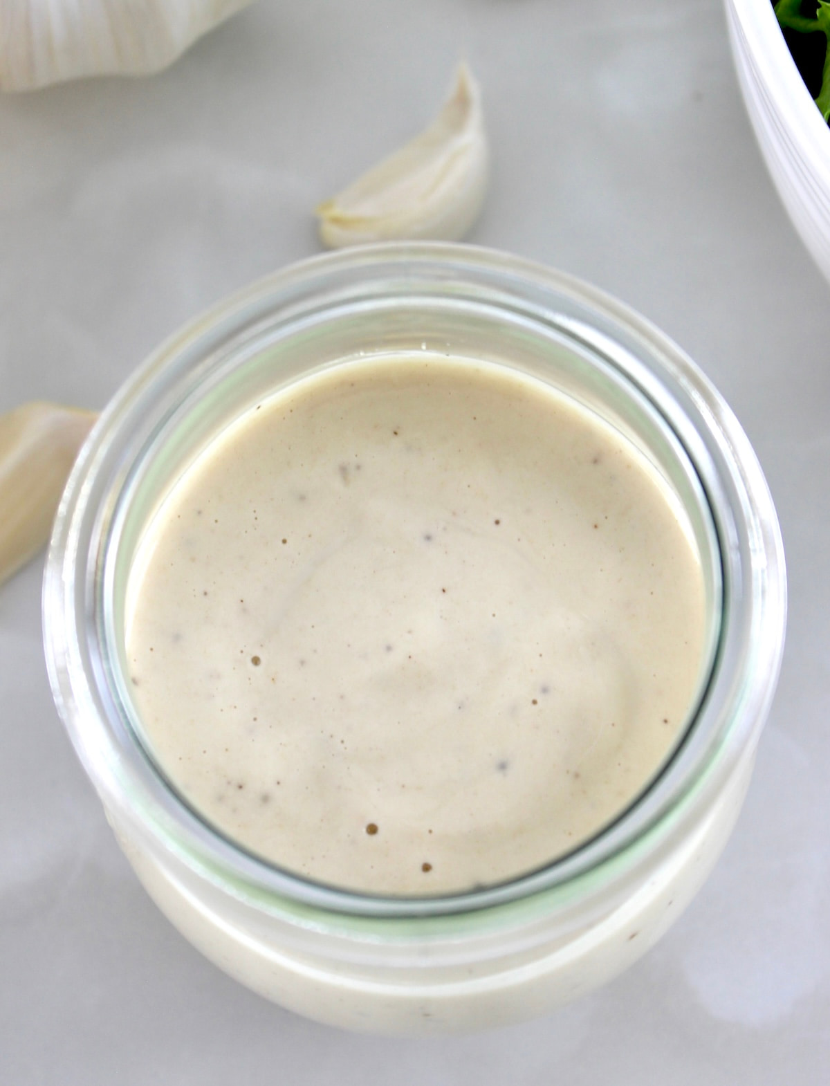 overhead view of Lemon Tahini Dressing in open glass jar