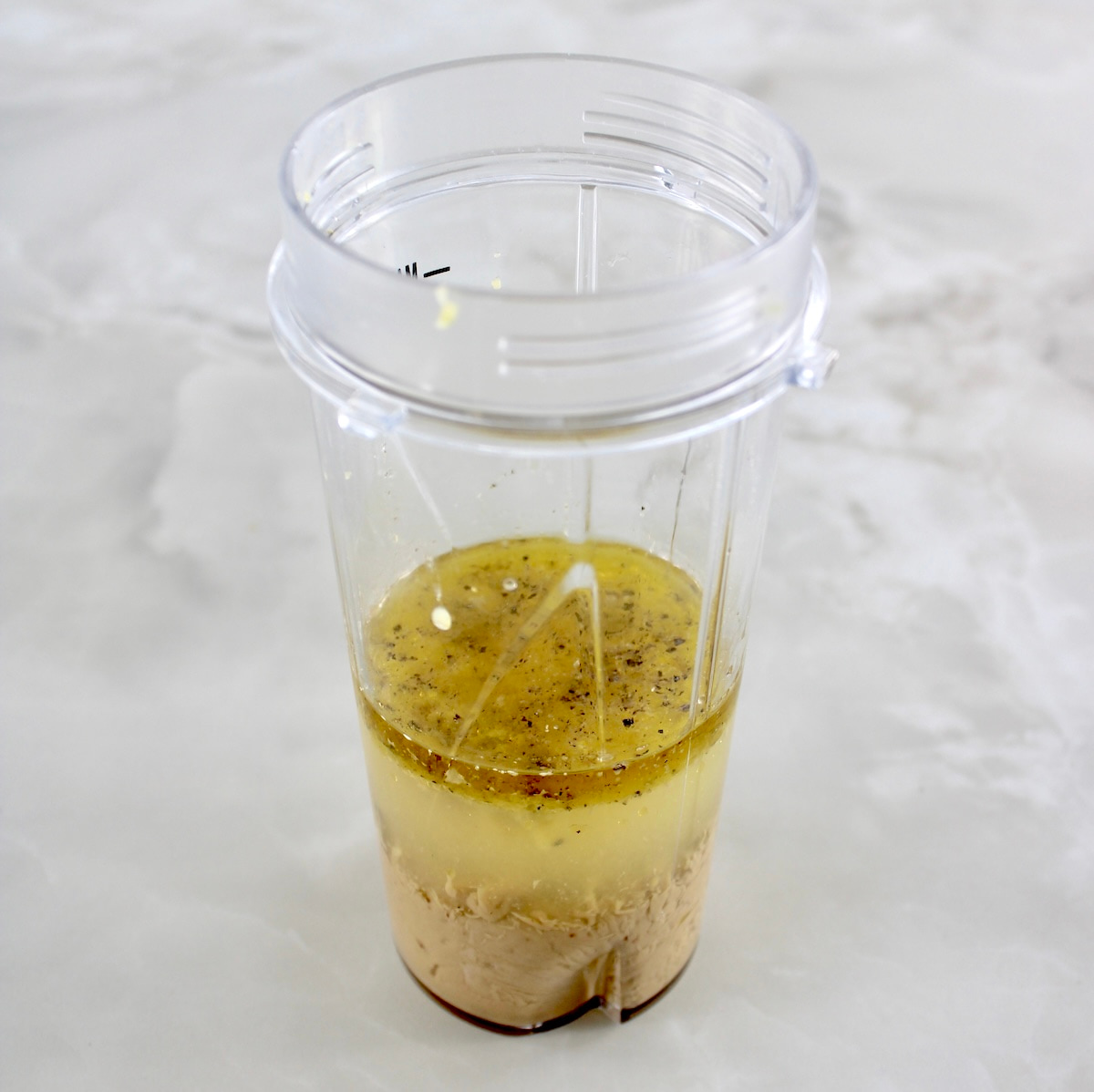 Lemon Tahini Dressing ingredients in bullet blender cup unmixed