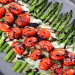 Asparagus Caprese on baking sheet with balsamic glaze