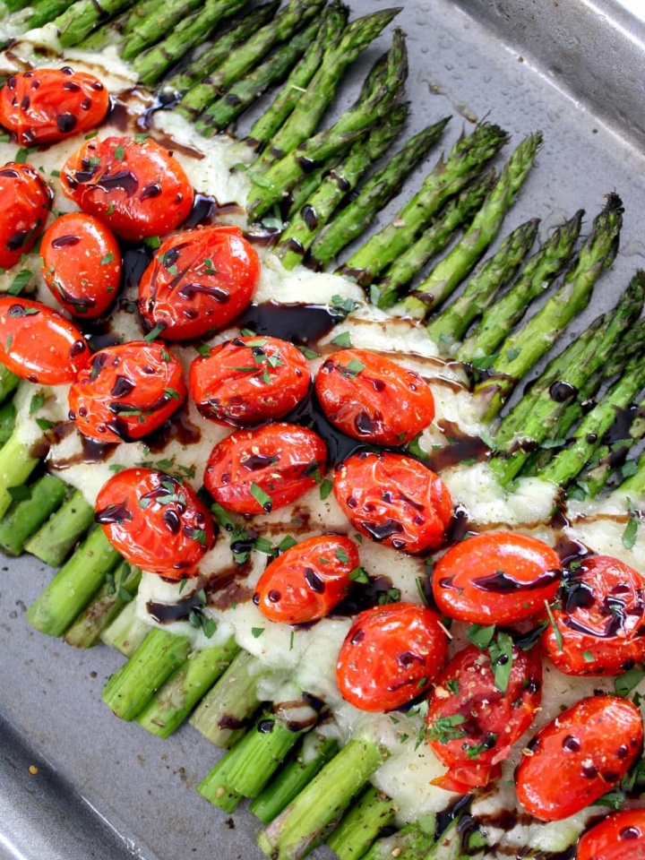 Asparagus Caprese on baking sheet with balsamic glaze