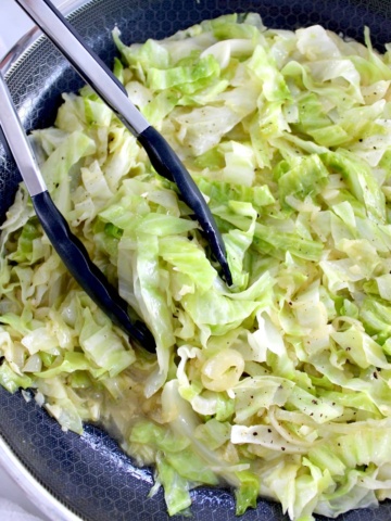 Buttered Cabbage in skillet with tongs