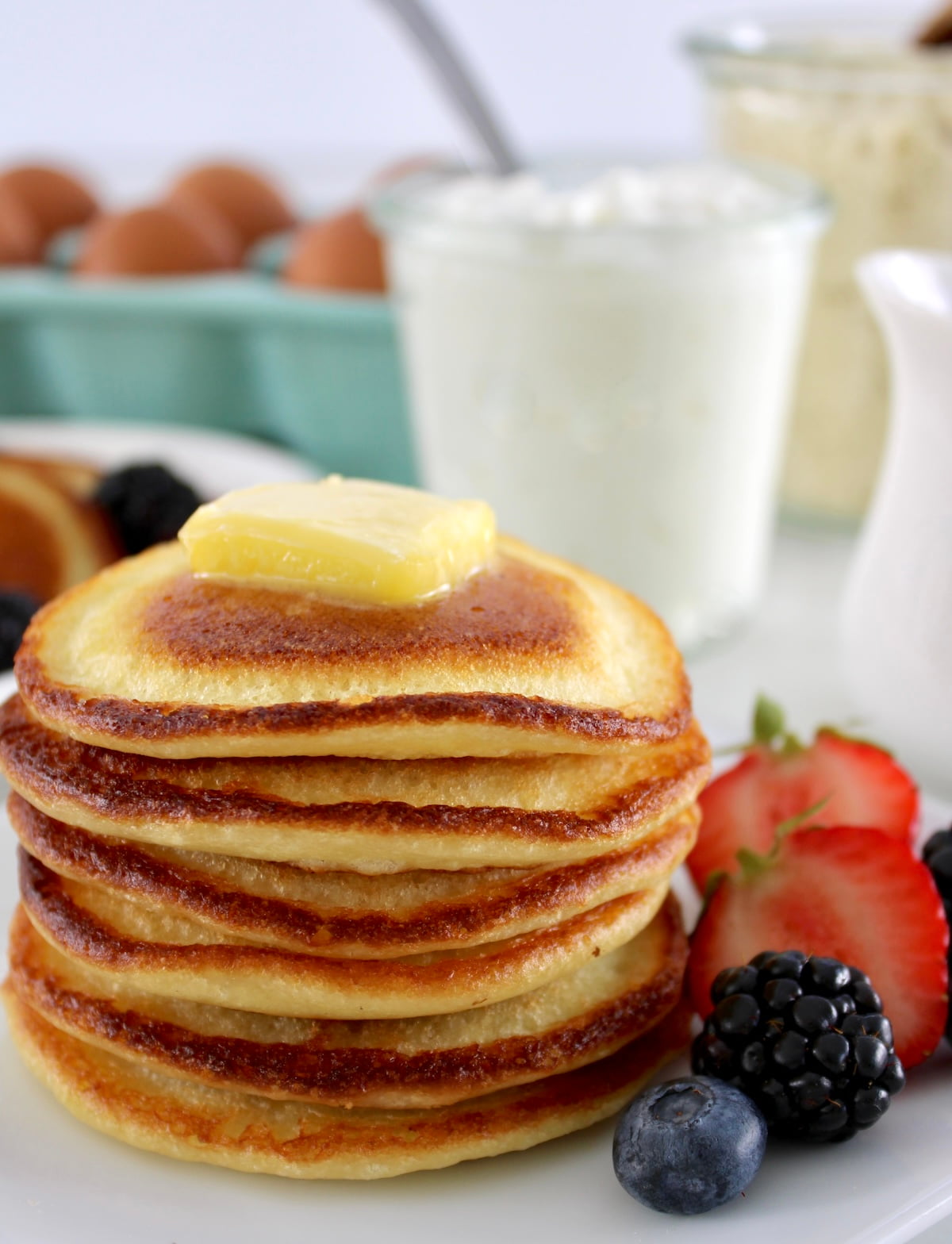 closeup side view of stack of Cottage Cheese Pancakes with pad of butter on top
