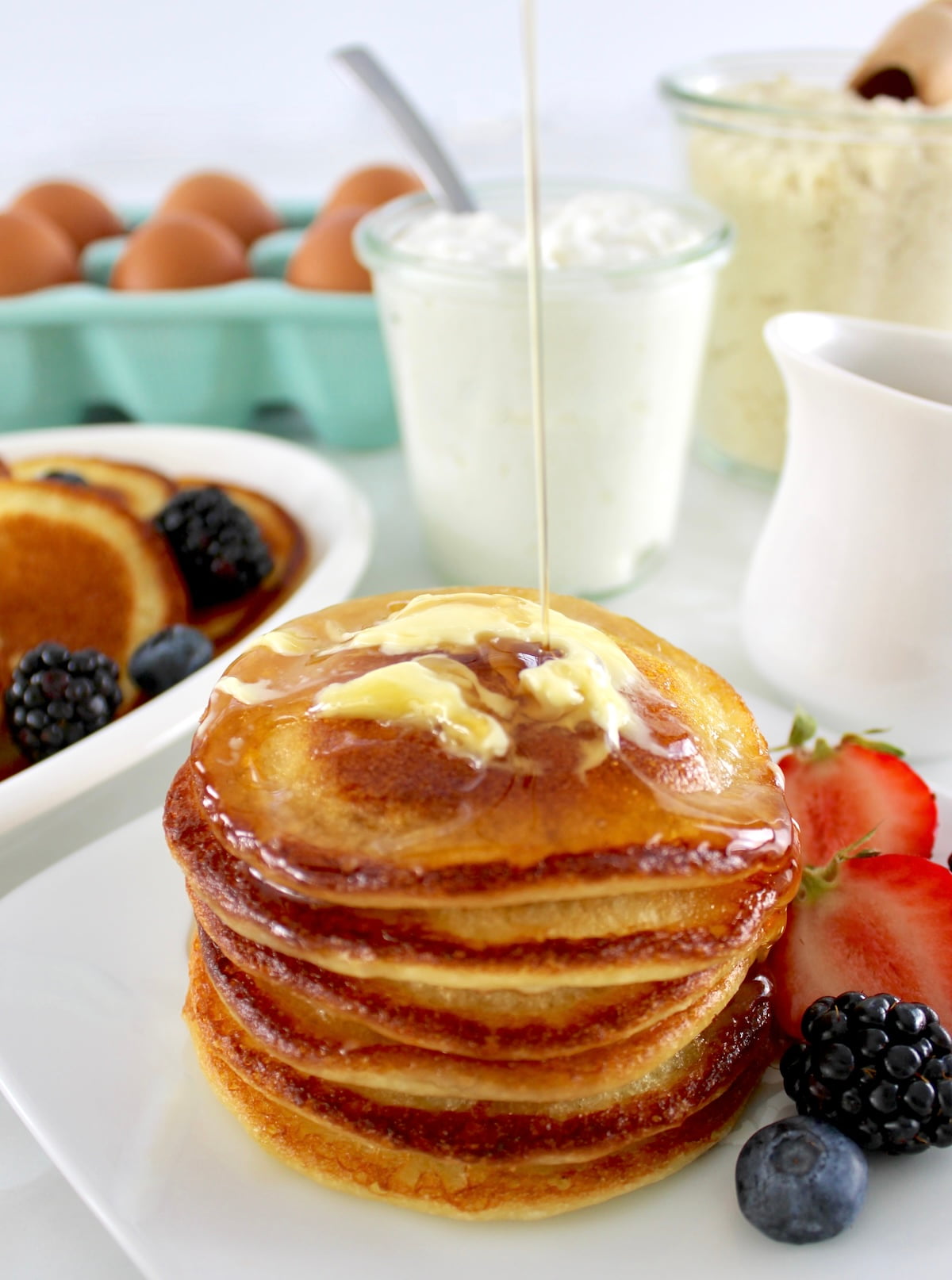 stack of Cottage Cheese Pancakes with butter and syrup pouring on top