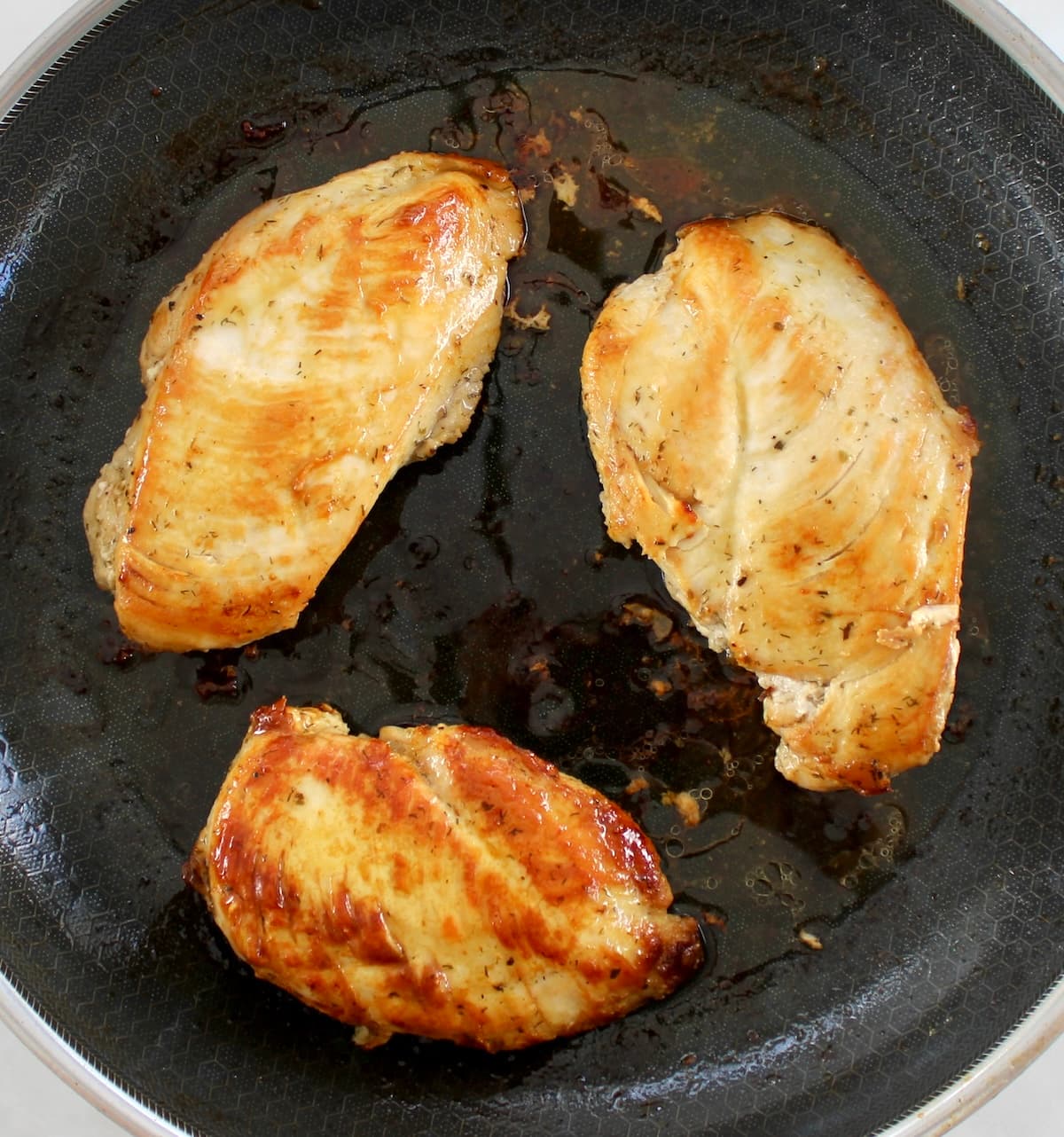 3 cooked chicken breasts in skillet