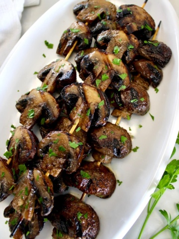 Grilled Mushroom Skewers on white oval platter
