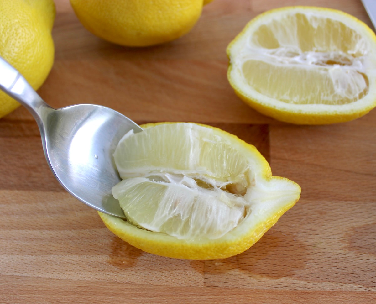 scraping out lemon flesh out of lemon with spoon