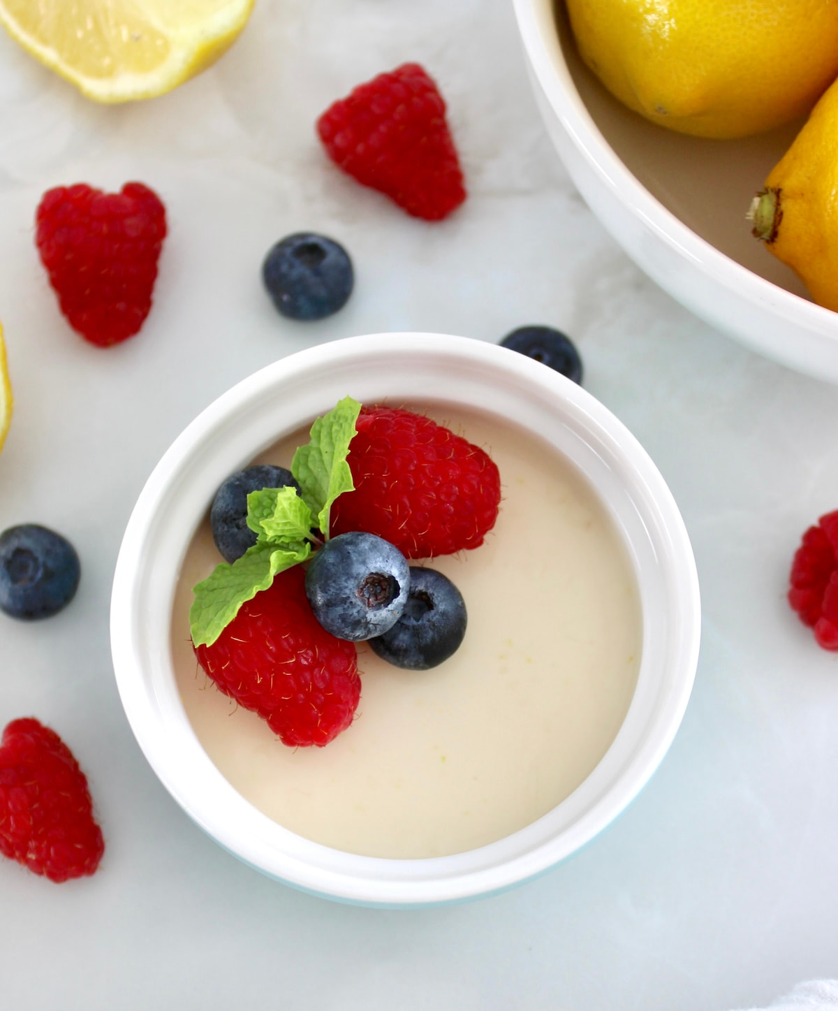 overhead view of Lemon Posset in ramekin with fresh berries and mint on top