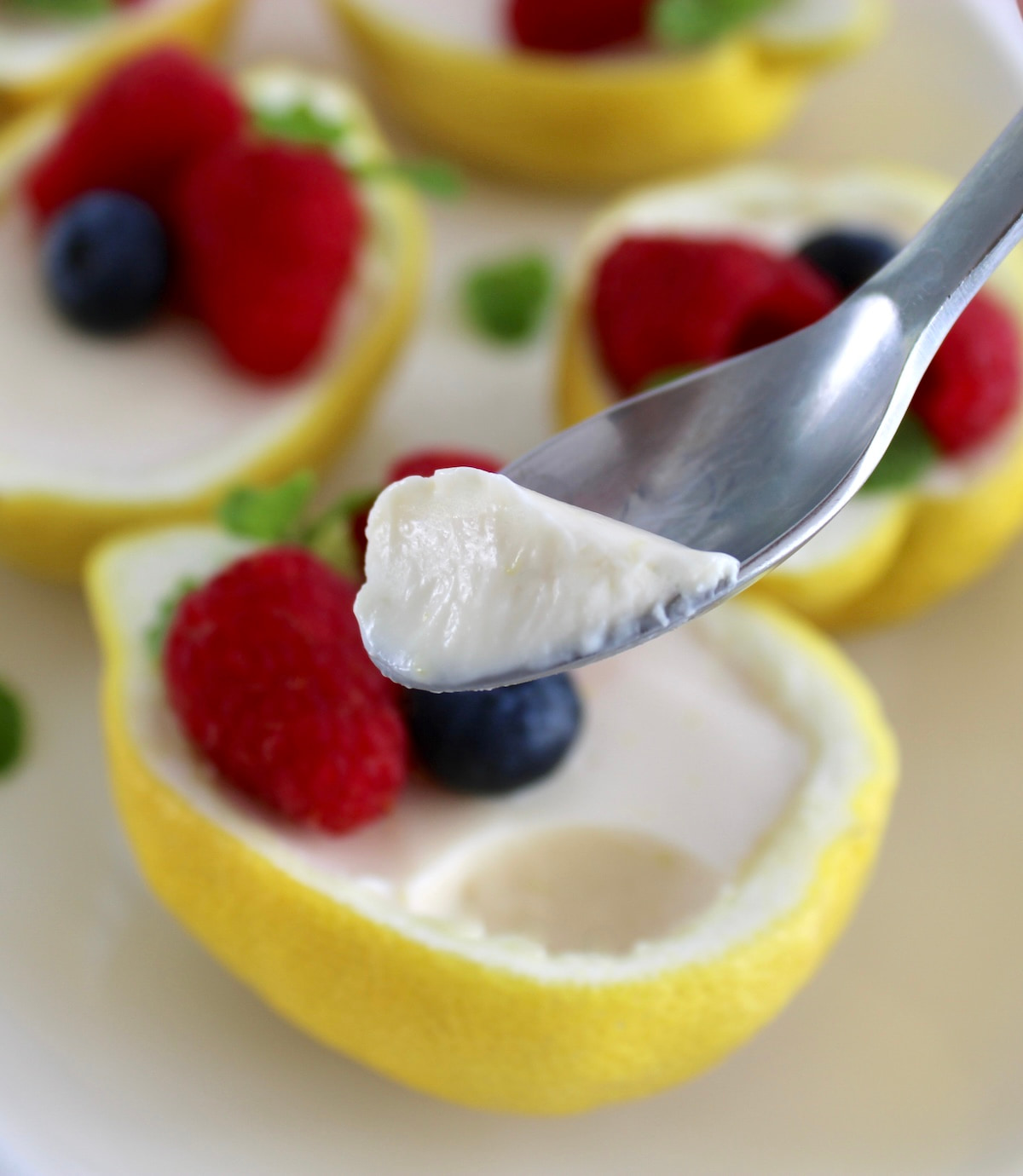 holding up spoonful of Lemon Posset over lemon half