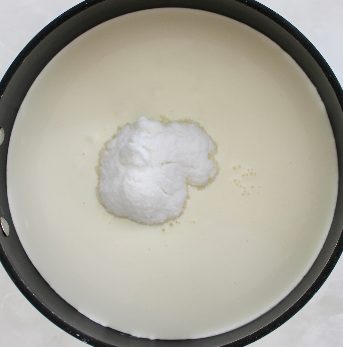 heavy cream in skillet with sweetener unmixed