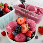 Mixed Berry Frozen Yogurt in blue bowl with fresh berries on top and in back