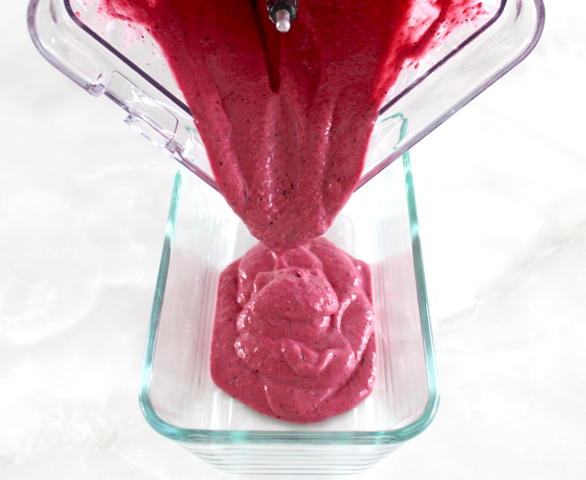 Mixed Berry Frozen Yogurt pouring into glass container