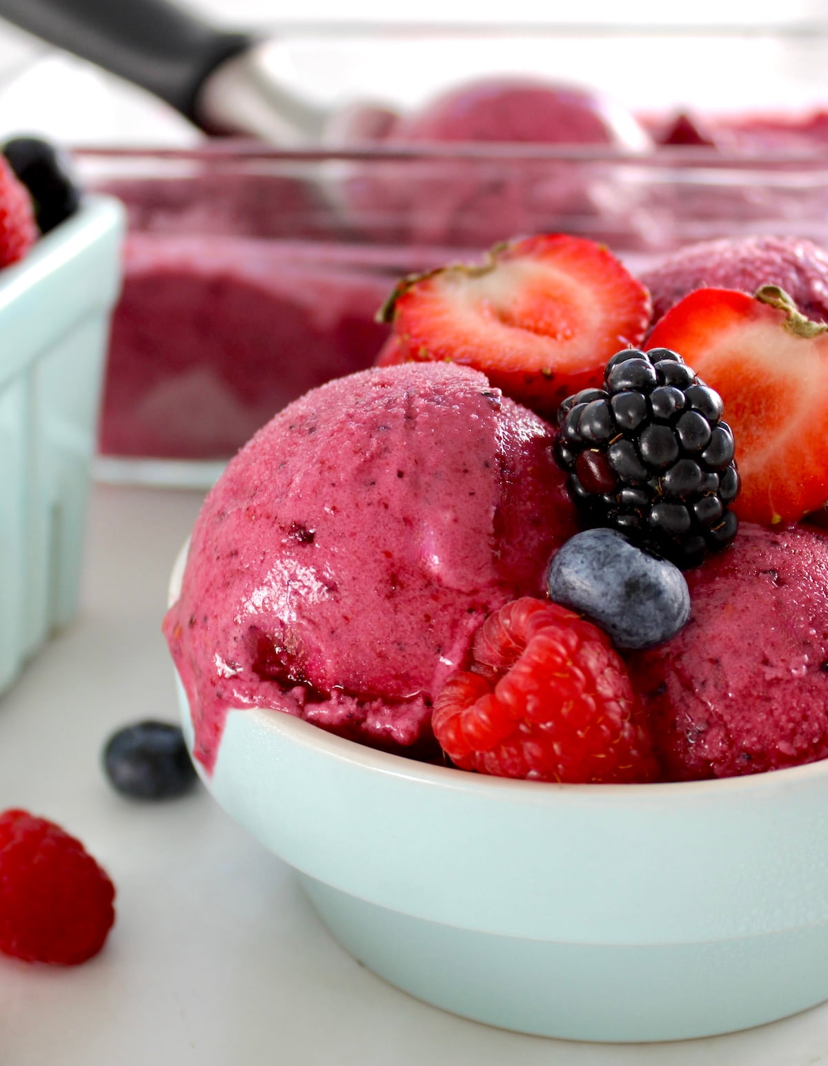 closeup of Mixed Berry Frozen Yogurt in blue bowl with fresh berries on top