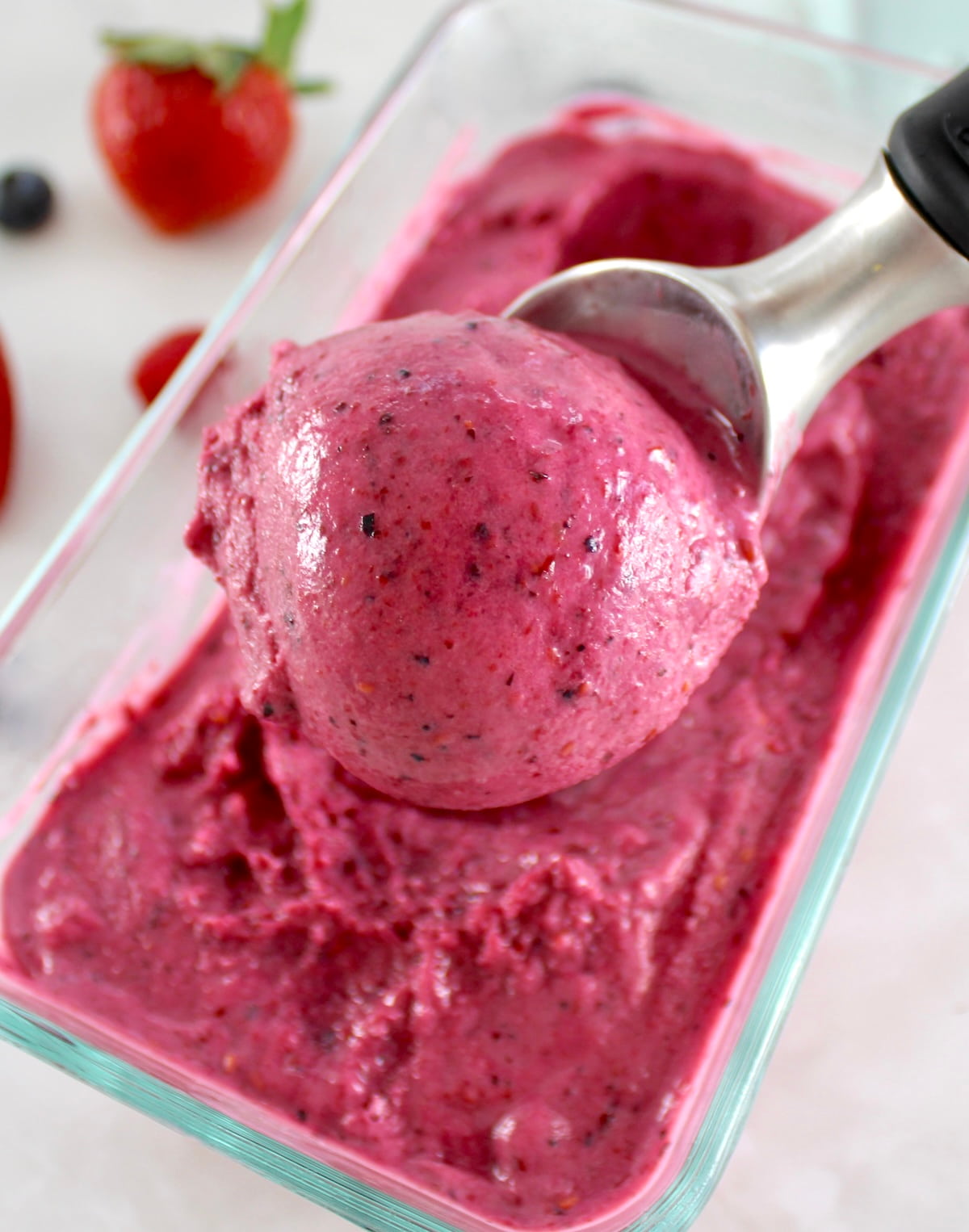 Mixed Berry Frozen Yogurt in glass container with ice cream scoop