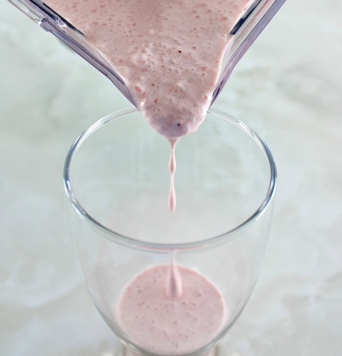Strawberry Protein Shake pouring from blender into glass