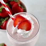 overhead closeup of Strawberry Protein Shake with strawberry slices and whip cream on top