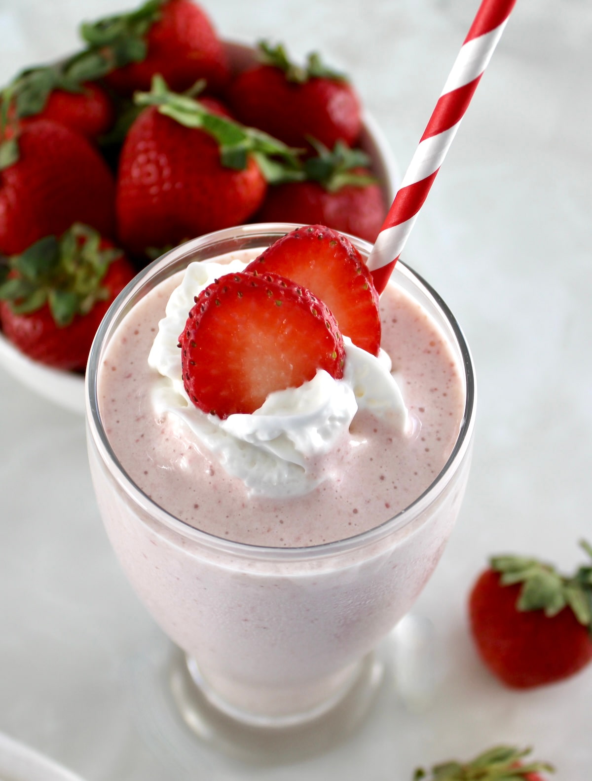 overhead view of Strawberry Protein Shake with strawberry slices and whip cream on top